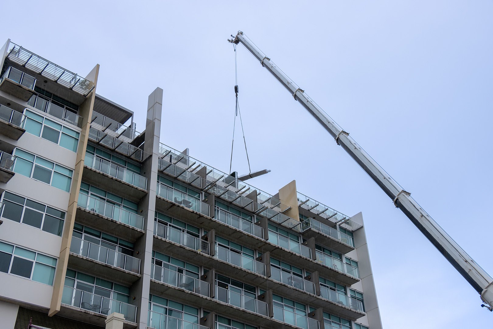 Crane Lifting Patio Components Onto Roof Dark Sky