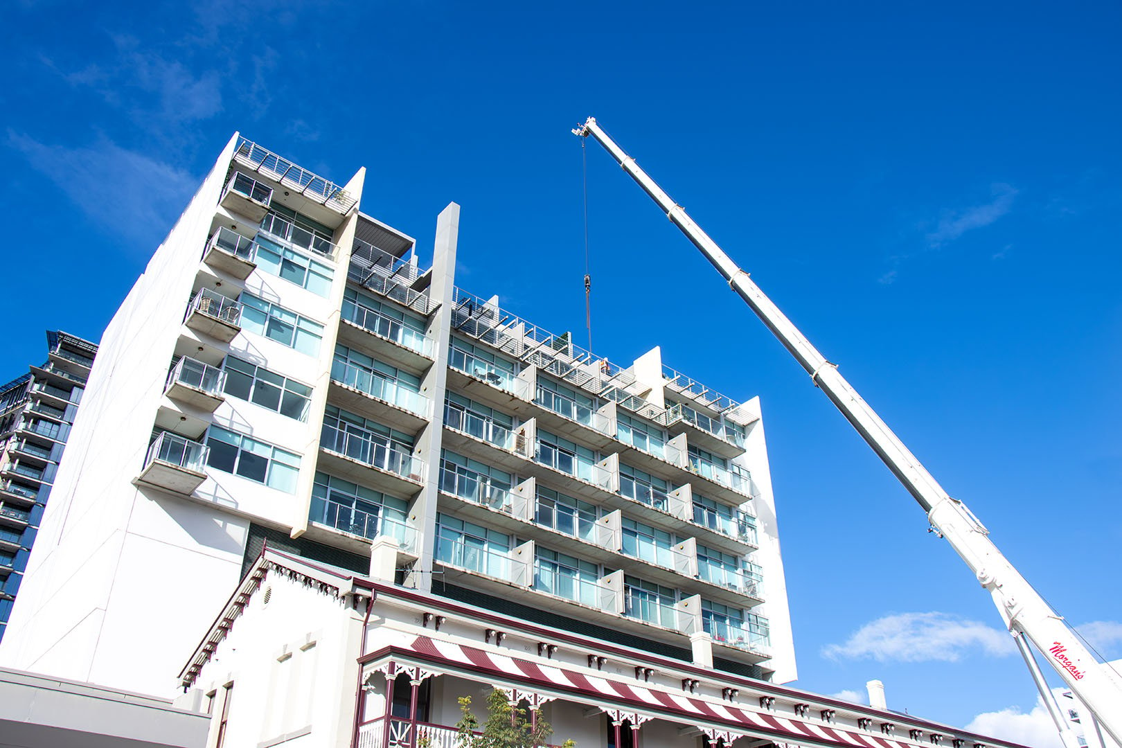 Crane Lifting Patio Components Onto Roof Blue Sky