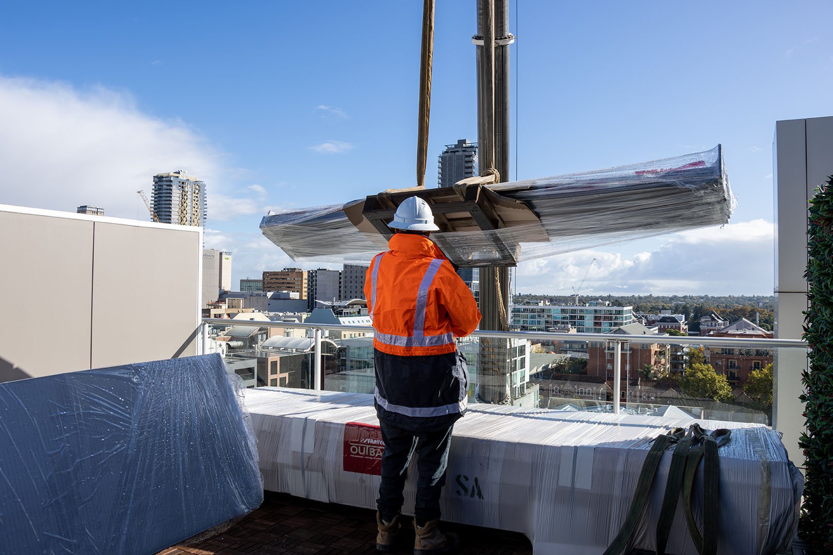 Man Placing Patio Components From Crane Onto Floor